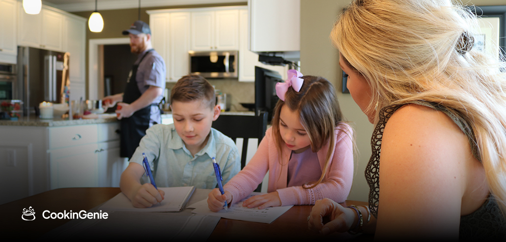 Mom with kids, chef cooking in background