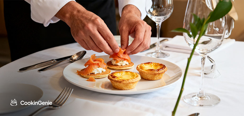 Chef plating French cuisine appetizers at a fine dining table