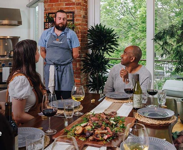 A private chef serving a curated meal to guests at a home dining table