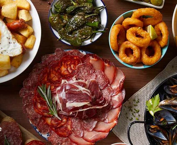 Spanish tapas spread with cured meats, patatas bravas, mussels, and calamari for a FIFA World Cup watch party