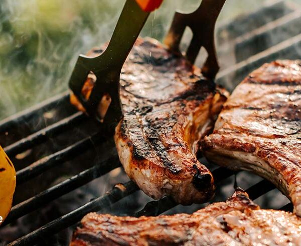 Private chef grilling steaks for a 4th of July party food menu during an outdoor summer cookout