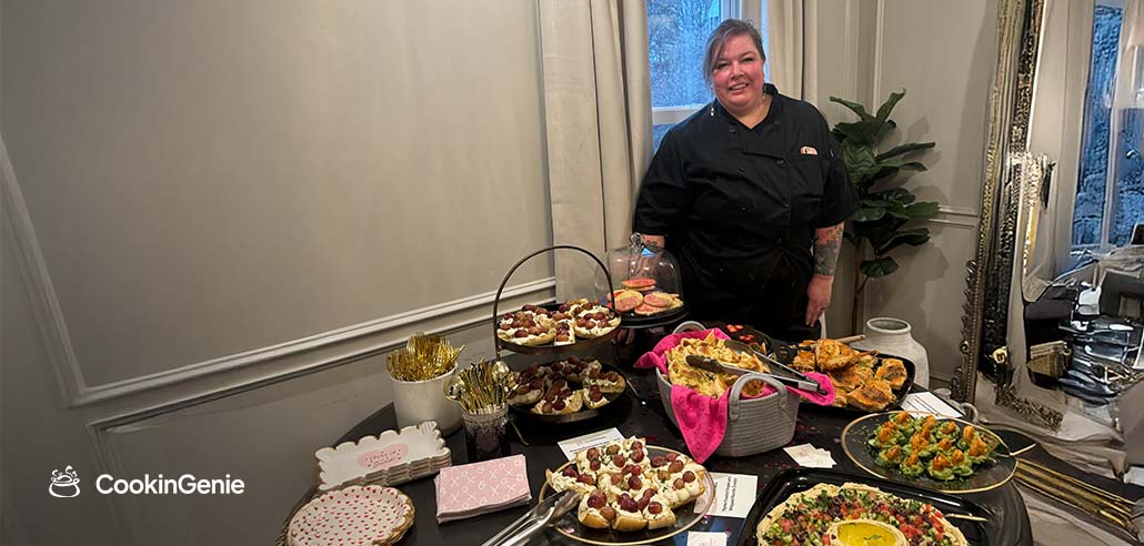 Chef Amanda Parks standing behind a spread of farm-to-table dishes at a private event in Columbus, Ohio
