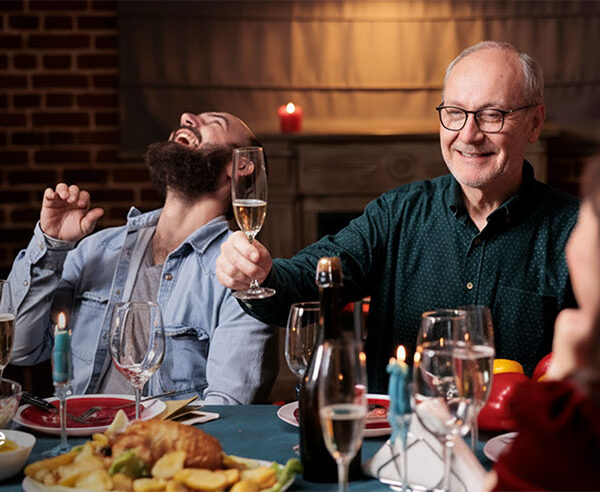Family laughing and toasting at a private chef dinner at home on Father's Day