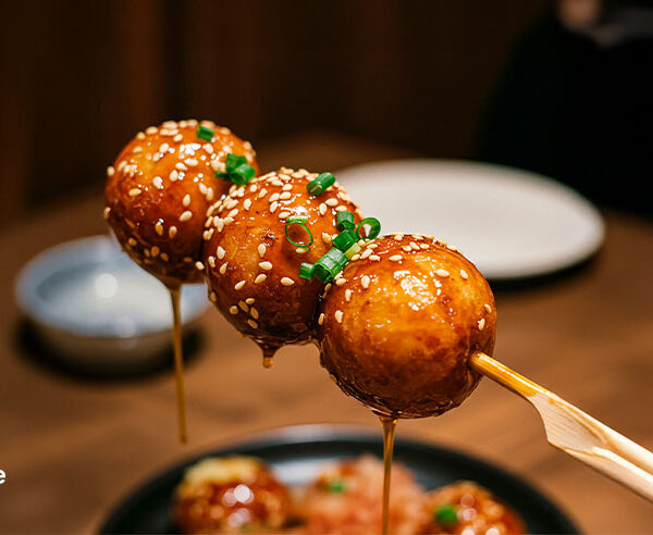Glazed meatball skewers with sesame seeds and spring onion