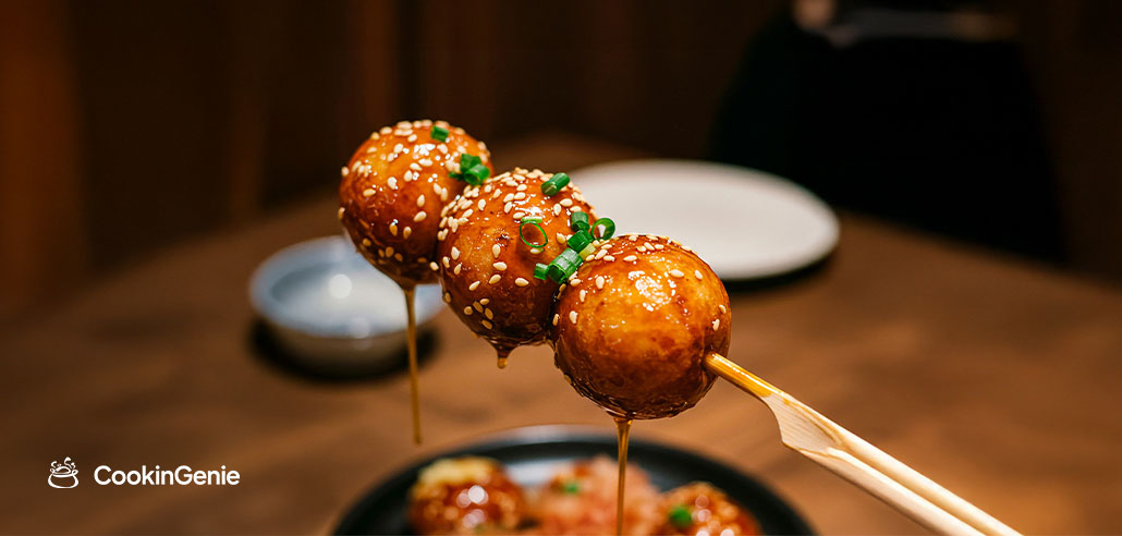 Glazed meatball skewers with sesame seeds and spring onion